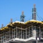 Concrete modern building under construction with scaffolding