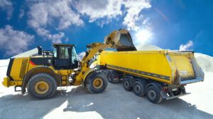 Radlader beldt LKW mit Baumaterial in einem Kieswerk // excavator loads trucks with construction material in a gravel pit